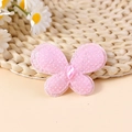 Macro detail of a pink glitter mesh butterfly accessory with center gemstone for DIY crafts - Pink