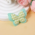Nahaufnahme von gelb-weiß kariertem Schmetterling-Stoffaufnäher für DIY-Haarschmuck - Blassgrün