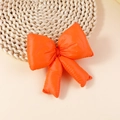 Macro detail of puffy orange ribbon bow accessory with soft cotton padding and glossy finish - Orange (FJ501)
