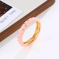 Detalle del brazalete bohemio de esmalte dorado con acabado de aceite rosa en bandeja - Oro+Rosa