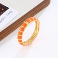 Detail of bohemian orange enamel and gold bangle with a spring hinge mechanism - Gold + Orange