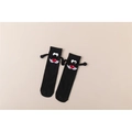 Detailansicht schwarzer 3D-Magnetsocken mit Händchenhalten-Effekt und Comic-Gesicht - Einheitsgröße / Rote Nase