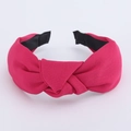 Close-up of knot design on fuchsia fabric headband with black non-slip lining - Rose Red