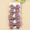 Set of four handmade dusty purple waffle knit bow hair clips on white card - Taro Purple