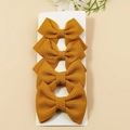 Set of four ginger yellow waffle fabric hair bows for kids on a white display card - Khaki