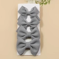 Set of four grey waffle texture bow hair clips neatly displayed on a white card - Gray