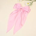 Elegant oversized pink satin bow hair clip with long ribbons on a minimalist background - Pink