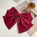Detail of a large wine red satin bow hair clip with elegant layered fabric texture - Red