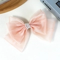 Elegante pinza para el cabello de organza rosa claro con perlas sobre una superficie blanca - Rosa