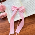 Pink satin hair bow clip with long ribbons on a vintage book with pink roses - Pink