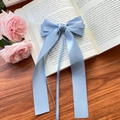 Elegant dusty blue satin ribbon bow hair clip on a vintage book with pink roses - Blue
