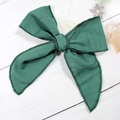 Barrette à cheveux nœud vert foncé en coton texturé avec bords cousus sur bois blanc - Style Tissu Vert Foncé