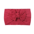 Vibrant red nylon baby headband featuring a large soft bow and ribbed knit texture - Burgundy