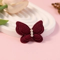 Rood stoffen vlinderaccessoire met witte parels op een witte gegolfde basis - Rood