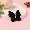 Elegante zwarte vlinder van stof met drie witte parels voor haar- of kledingaccessoires - Zwart