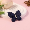 Donkerblauwe stoffen vlinder accessoire met parels op een witte presentatieschotel - Donkerblauw