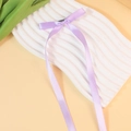 Elegant light purple satin bow hair clip with long ribbons on a decorative tray - Lavender