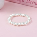 Elegante pulsera de perlas blancas estilo francés sobre fondo rosa romántico y suave - 8mm