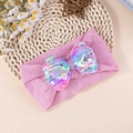 Détail d'un bandeau bébé avec gros nœud en paillettes irisées sur tissu violet élastique - Rose Violet