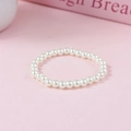 Elegant single strand white faux pearl bracelet with soft luster on a pink background - 6mm