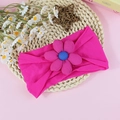 Bandeau élastique rose pour bébé avec fleur au cœur bleu sur un tapis tressé - Rose rosé