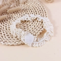 Creamy white handmade crochet lace baby headband with round felt base on woven mat - Off White