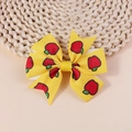 Detail shot of yellow grosgrain ribbon bow with cute red apple and green leaf print patterns - Yellow Apple Style