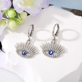 Détail de boucles d'oreilles œil de démon avec cils et strass sur socle en pierre - Oeil Bleu Blanc Argent