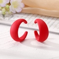 Boucles d'oreilles créoles C rouges épaisses au fini mat sur une surface texturée - Rouge
