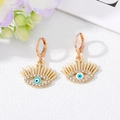Detail view of gold evil eye earrings with blue enamel and sparkling white rhinestones - White Green Eye Gold