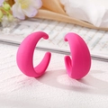 Vue détaillée des boucles d'oreilles créoles C rose fluo mat sur un support élégant - Rose