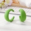 Matte fruitgroene C-vormige geometrische oorringen op een elegante lifestyle achtergrond - Grasgroen