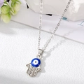 Dettaglio del ciondolo mano di Fatima con occhio greco blu e cristalli scintillanti - Collana Mano di Fatima Argento Grande Occhio Blu Bianco