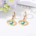 Detail of gold evil eye hoop earrings with blue stones and hollow eyelash design - Green And White