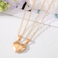 Detailed view of gold magnetic heart pendant necklaces on a stylized background - Double Matte Gold Heart