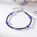 Macro detail of Bohemian Evil Eye bead bracelet with blue crystals and lobster clasp - Black Rope Two Rhinestone Blue Eyes