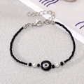 Detailed macro view of black seed bead bracelet featuring an evil eye charm and lobster clasp - Black Beads and Pearl with Black Eye