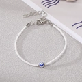 Close-up of bohemian white seed bead bracelet featuring a blue evil eye bead and silver clasp - White Beads with Silver Blue Eye