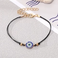 Detail shot of Evil Eye beaded bracelet with blue rhinestones and adjustable gold chain - Black Rope Gold Rhinestone Eye