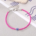 Close-up of bohemian rose red beaded bracelet with blue evil eye charm and silver clasp - Rose Red Beads with Silver Blue Eye