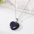 Detail of blue sandstone heart pendant on a silver metal chain over a white surface - Blue Galaxy