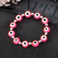 Vue détaillée de dessus du bracelet œil maléfique en résine rose avec perles en argent - Rose rouge