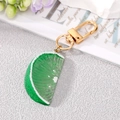 Detail shot of realistic green lime slice keychain with golden metal clasp and ring - Lime Slice Keychain
