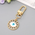 Porte-clés œil bleu doré avec design circulaire évidé et strass brillants - Œil Ajouré Blanc