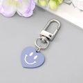 Portachiavi a cuore viola con chiusura a D in metallo argento su sfondo con fiori - Cuore Sorridente Blu