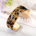 Detailed macro of gold plated cuff bracelet with colorful crushed stones and crystals - Black Stone Bangle