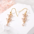 Detailed close-up of golden butterfly earrings with sparkling pear-cut zircon crystals - Double Butterfly