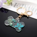 Porte-clés créatif en forme d'os avec fleurs séchées bleues et anneau doré - Fleur Bleue