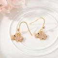 Detailed view of gold rhino earrings with white cubic zirconia and fishhook closure - Rhino