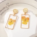 Detail of gold rectangular earrings featuring real yellow pansy dried flowers in resin - Style 2 Yellow Flower